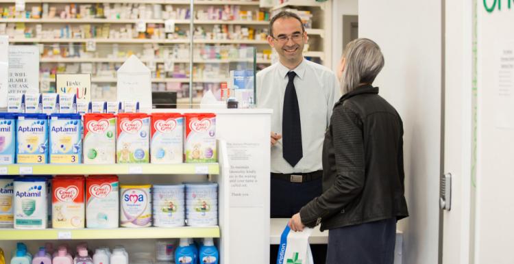 Women reading advice and information leaflet by advice stand